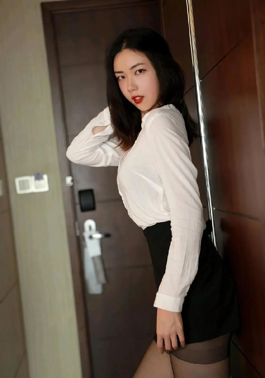 白色衬衫搭配半身裙高跟鞋，用透明的黑色丝袜修饰，优雅又干练